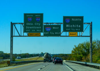 Overhead gantry signs for I-35 in Oklahoma with trucks on road with blue sky (image: Oleg Kovtun/Dreamstime.com)